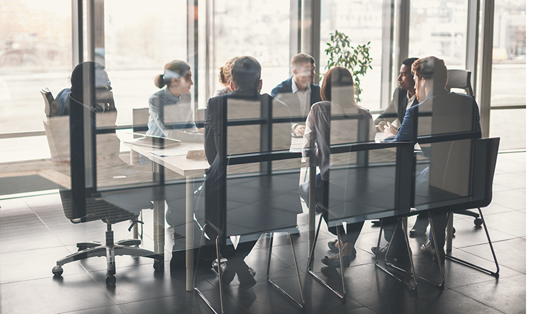 Managerinnen und Manager sitzen an einem Konferenztisch