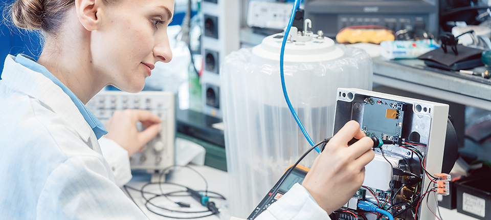Engineer woman measuring electronic product on test bench